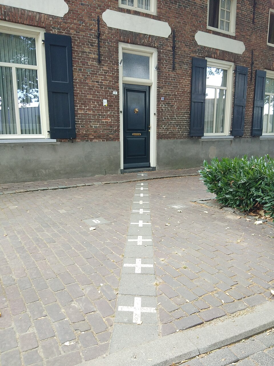 A building in Baarle-Hertog shared between Belgium and the Netherlands, with border markers on the facade indicating the precise line between two sovereign nations