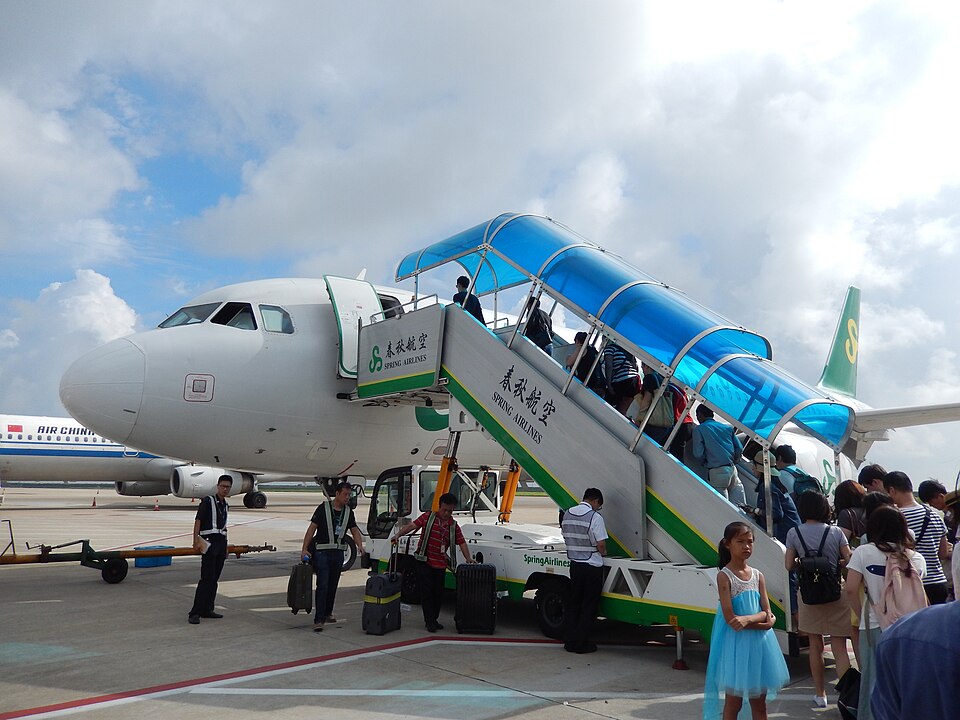 Passengers boarding a commercial aircraft via boarding stairs, a scene that captures the universal hope of securing a preferred seat