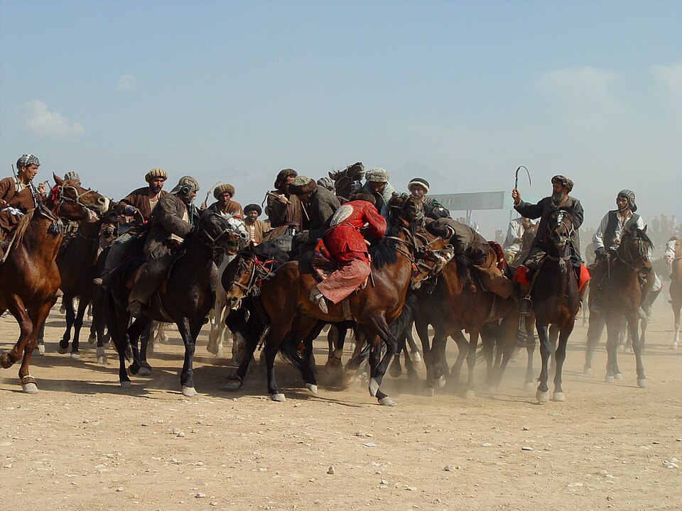 Buzkashi riders on horseback competing for the goat carcass in Central Asia