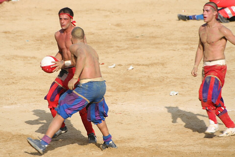 Calcio Storico players in period costumes competing in the sandy arena of Piazza Santa Croce, Florence