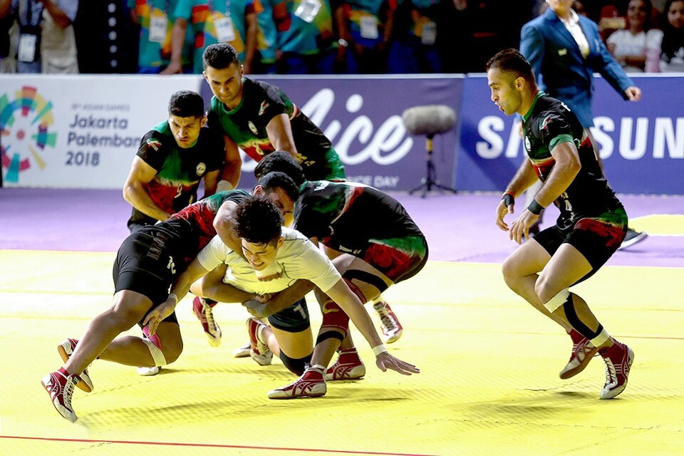 Kabaddi players competing in an international match, wrestlers grappling on a mat