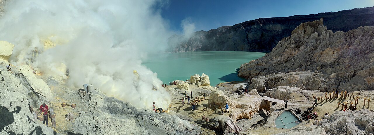 A sulphur miner near the acidic turquoise crater lake of Kawah Ijen in East Java, Indonesia, amid volcanic fumes