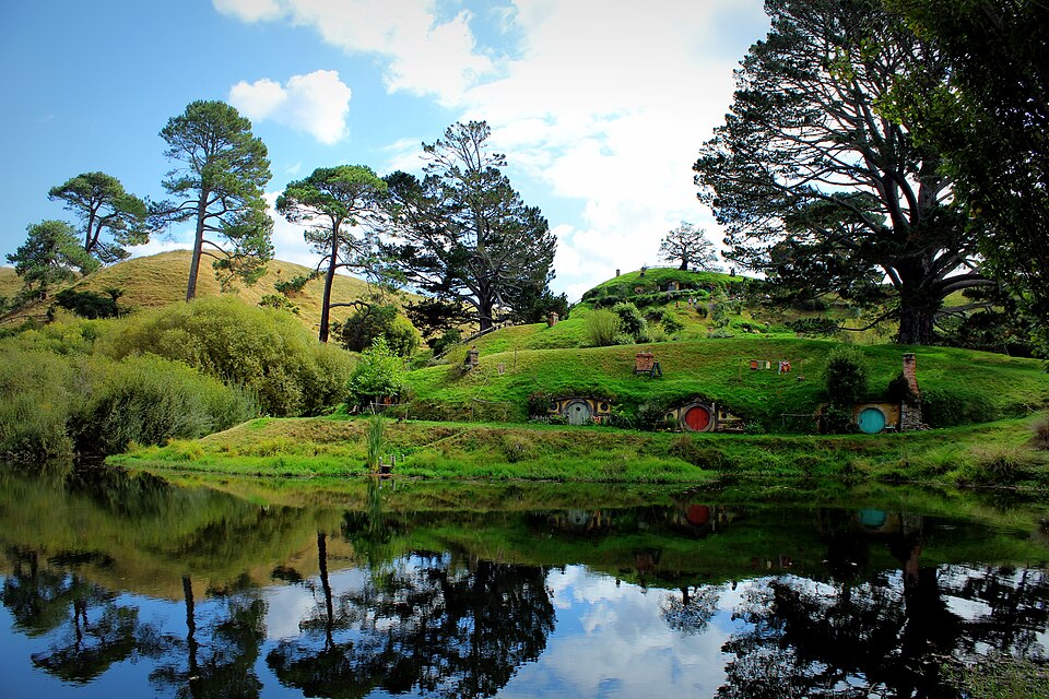 Green hillside with round hobbit hole doors at the Hobbiton movie set in Matamata, New Zealand