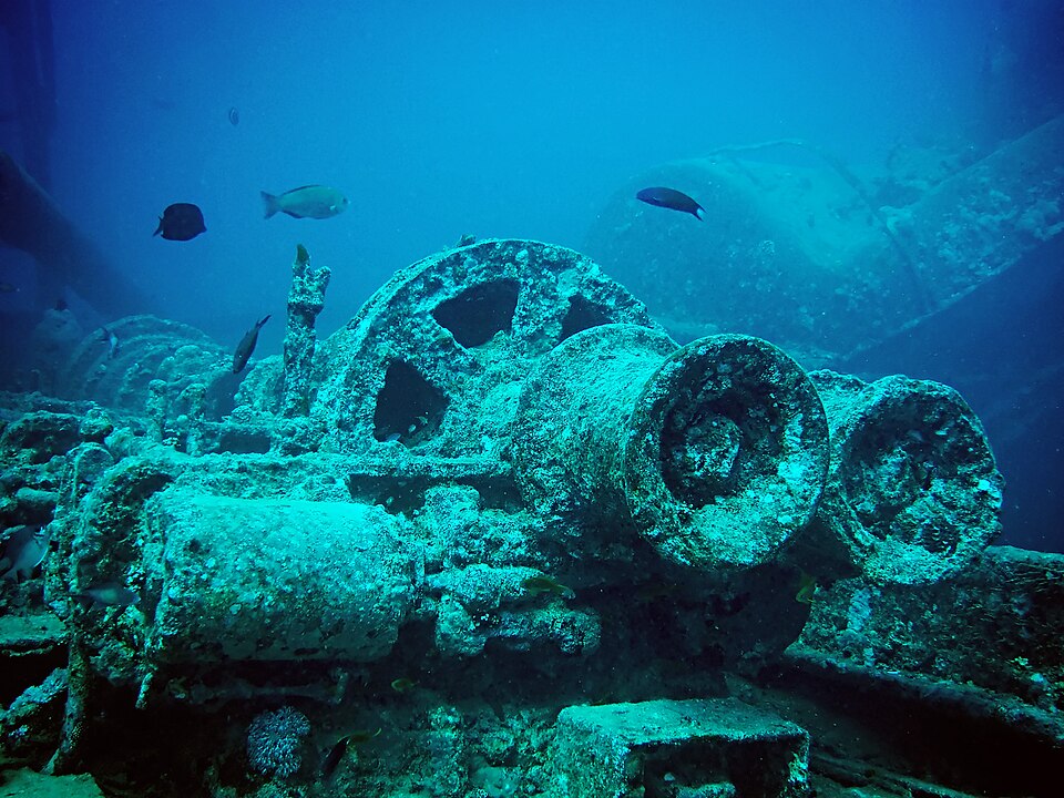 Wreckage inside the SS Thistlegorm showing train parts and artifacts encrusted with coral