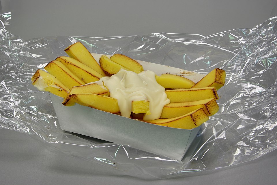 A paper cone of crispy double-fried Belgian fries served with mayonnaise