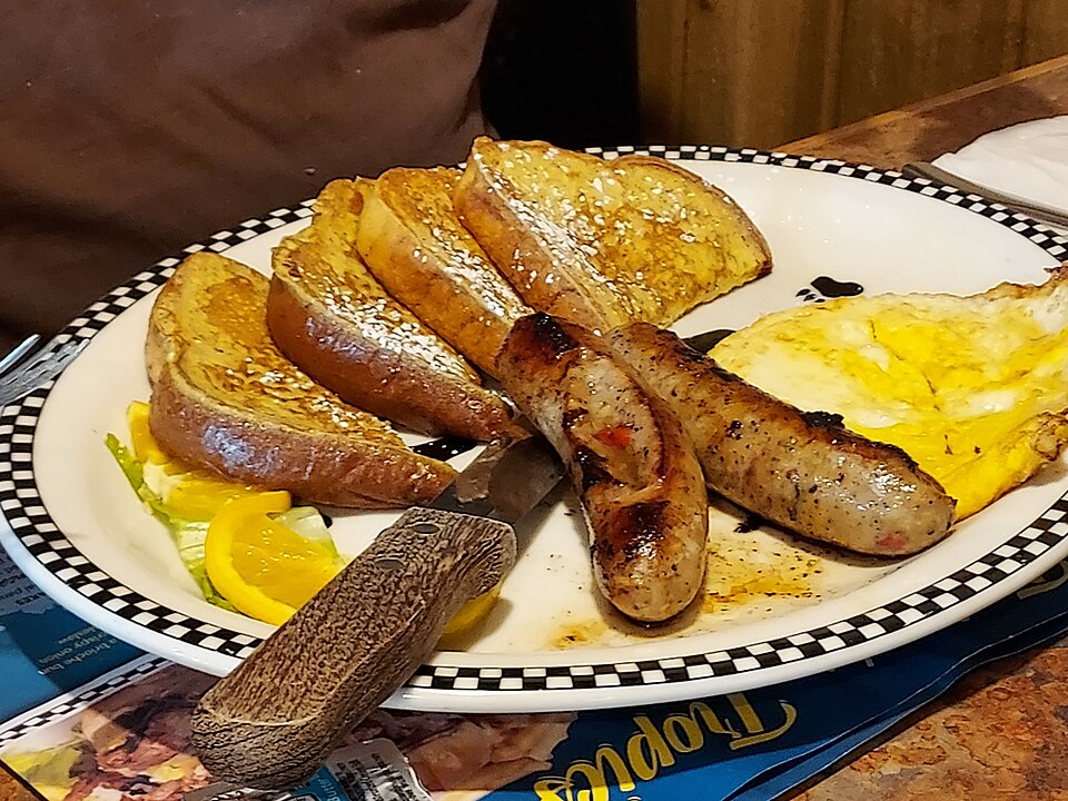 Slices of French toast dusted with powdered sugar and topped with syrup