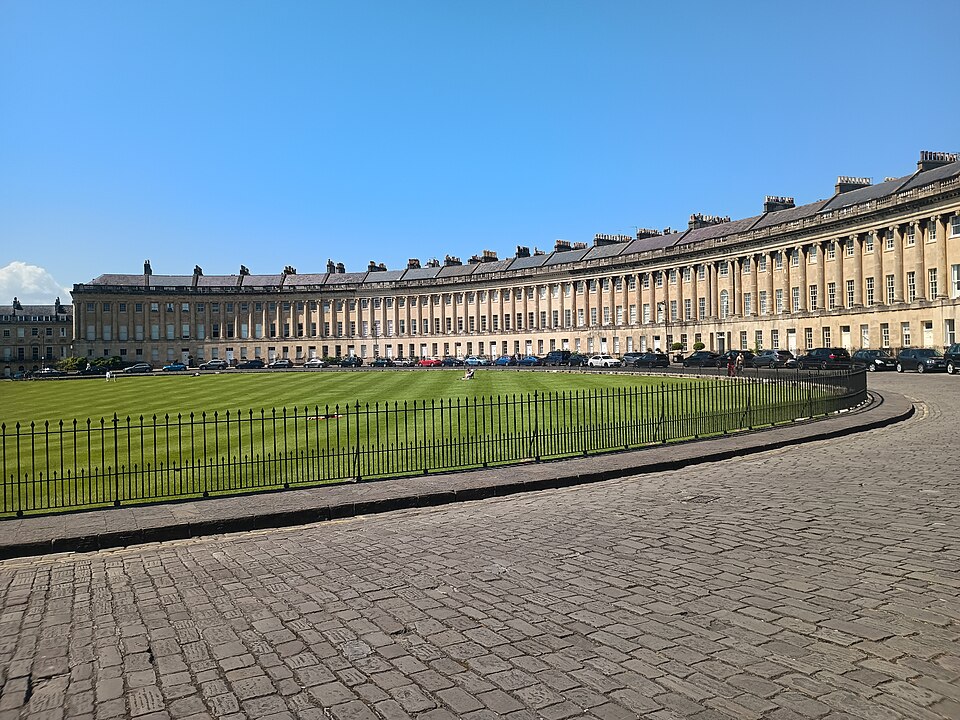 The Royal Crescent in Bath, a sweeping arc of Georgian townhouses under blue skies