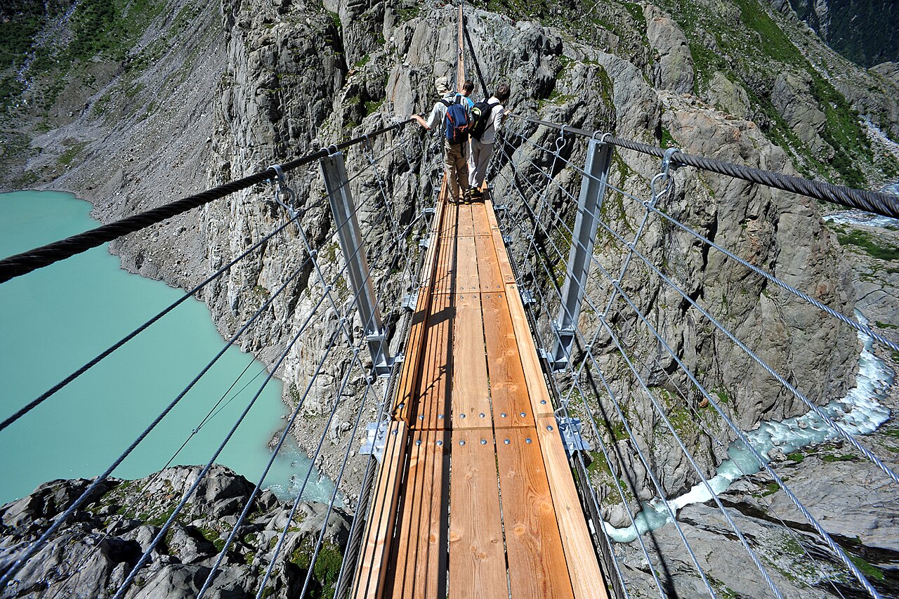 The Trift Bridge, a long pedestrian suspension bridge over a glacial lake in the Swiss Alps