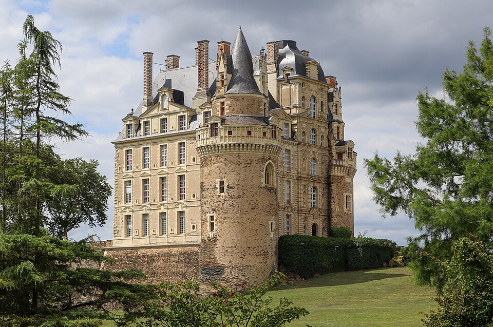 The exterior of Château de Brissac in the Loire Valley, a tall French château with turrets and formal gardens