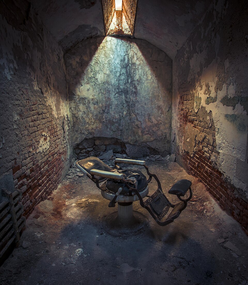 A dentist's chair inside Eastern State Penitentiary, Philadelphia, surrounded by peeling walls and abandoned equipment