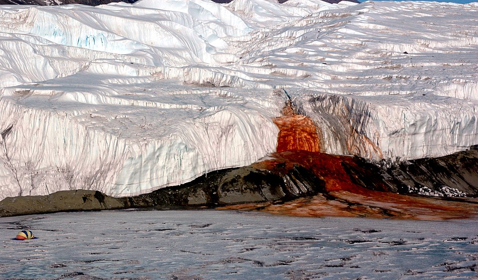 Blood Falls in Antarctica, a vivid red waterfall seeping from the white Taylor Glacier into a frozen lake