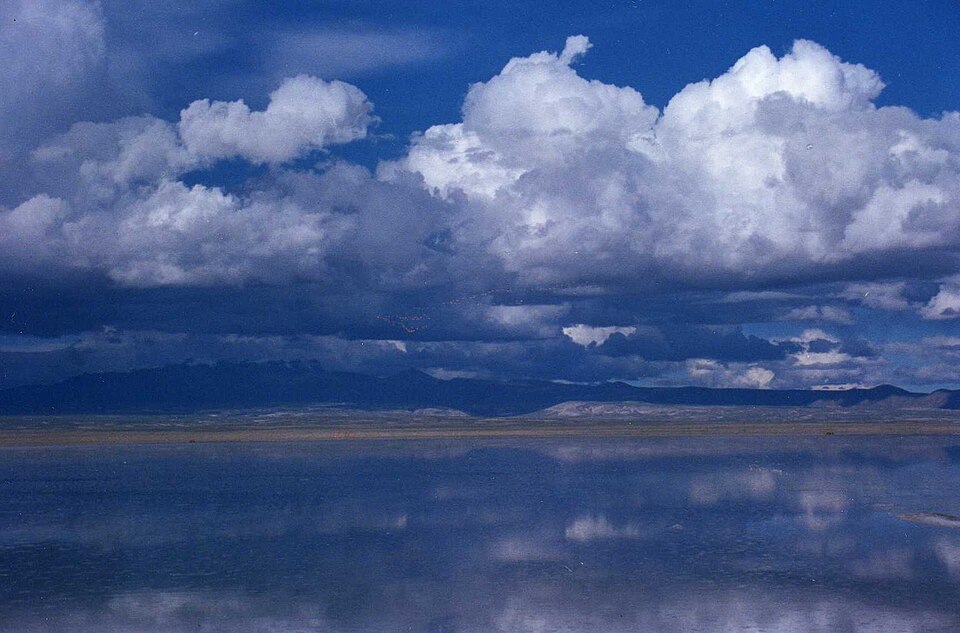 Salar de Uyuni in Bolivia at dusk, the vast salt flat reflecting the sky in a perfect mirror image at the horizon