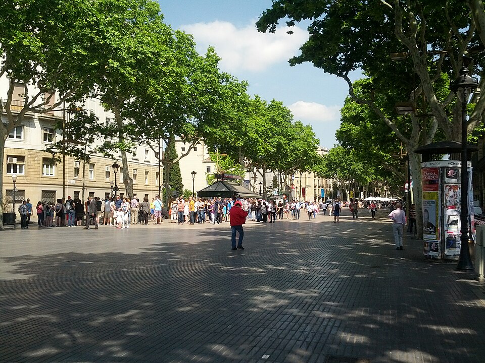 Crowds funnelling along the wide pedestrian boulevard of Las Ramblas in Barcelona
