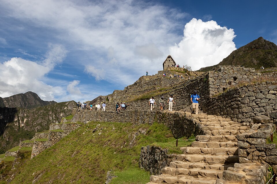 Tourists at Machu Picchu with the Inca ruins and Huayna Picchu mountain in the background