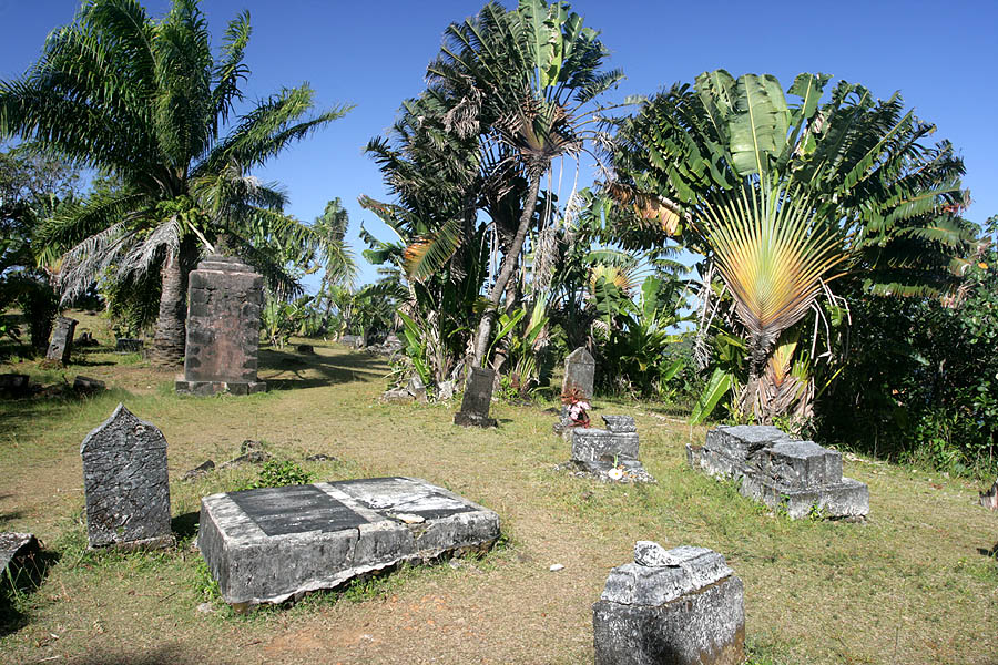 The Pirates Cemetery on Ile Sainte-Marie Madagascar, showing skull-and-crossbones headstones among tropical vegetation