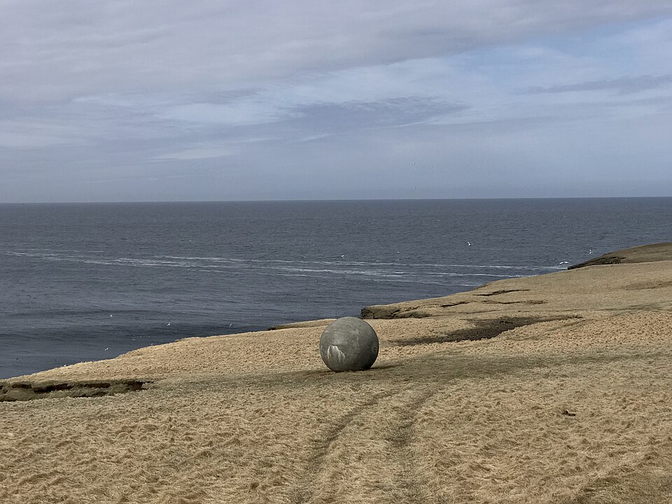 The Orbis et Globus concrete sphere marking the Arctic Circle on the clifftop of Grimsey island off northern Iceland, with the sea behind