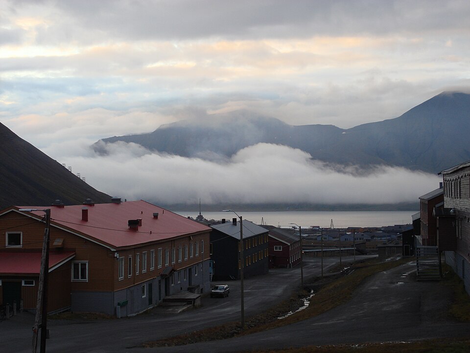 Midnight summer light over the buildings and fjord of Longyearbyen in Svalbard, with low cloud on the mountains
