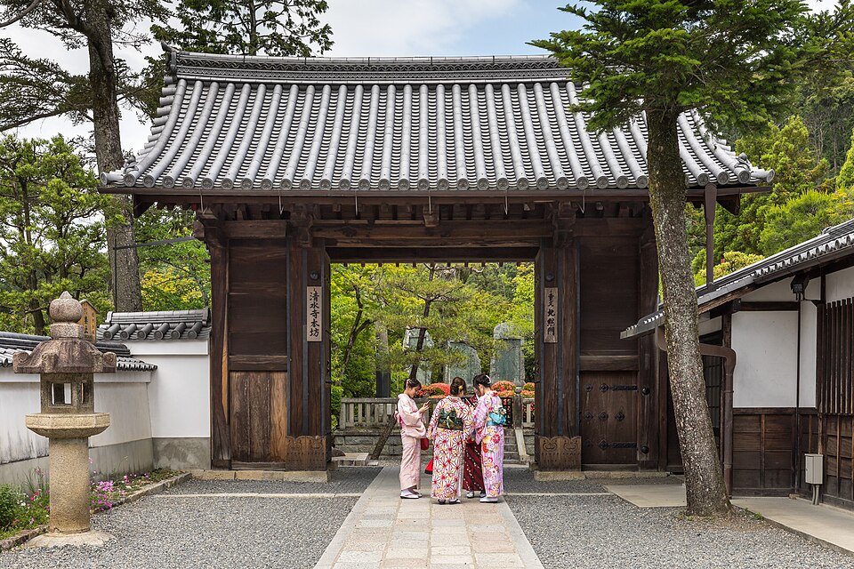 Visitors in kimono at the wooden gate of Kiyomizu-dera temple in Kyoto