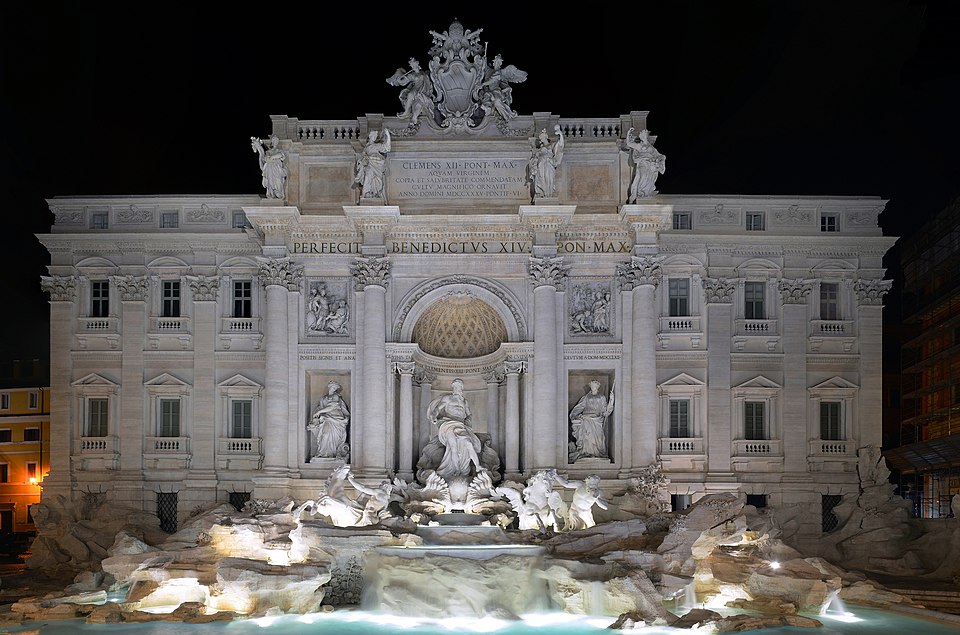 The Trevi Fountain illuminated at night, Rome, Italy, with tourists surrounding the baroque landmark