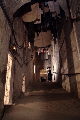 A narrow stone-walled corridor in the Real Mary Kings Close, preserved beneath Edinburgh Old Town, Scotland