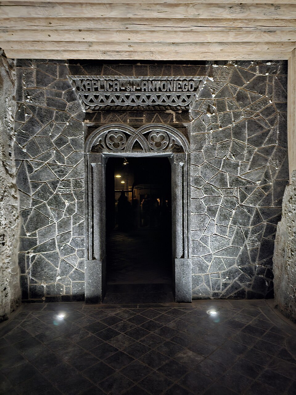 The ornate underground Chapel of Saint Kinga carved entirely from rock salt inside the Wieliczka Salt Mine in Poland, lit by salt-crystal chandeliers