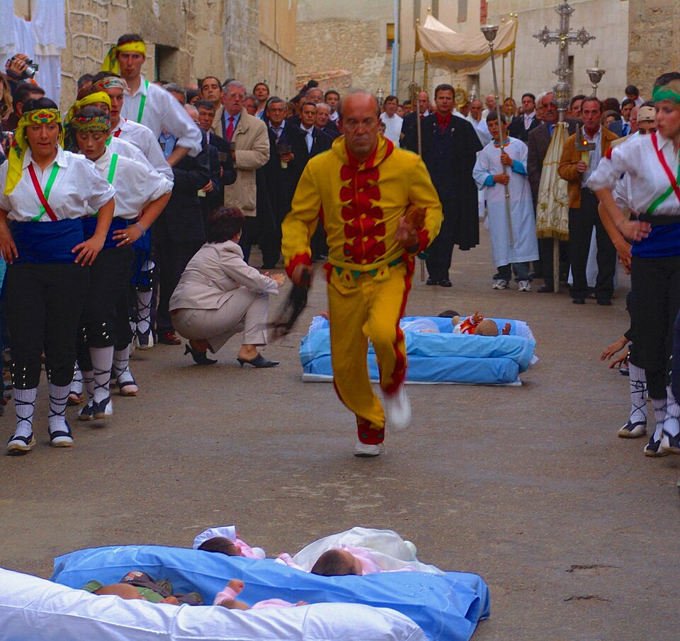 El Colacho festival in Castrillo de Murcia, Spain - a man in a devil costume mid-leap over a row of infants, a practice running since 1620 with a perfect safety record.